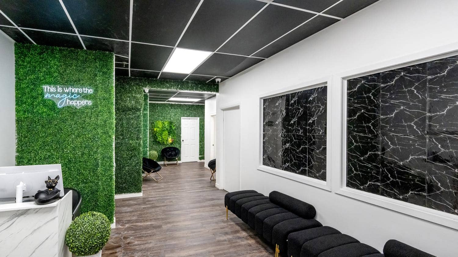 The corridor into the clinic, with a moss wall, marble panels and bench seating
